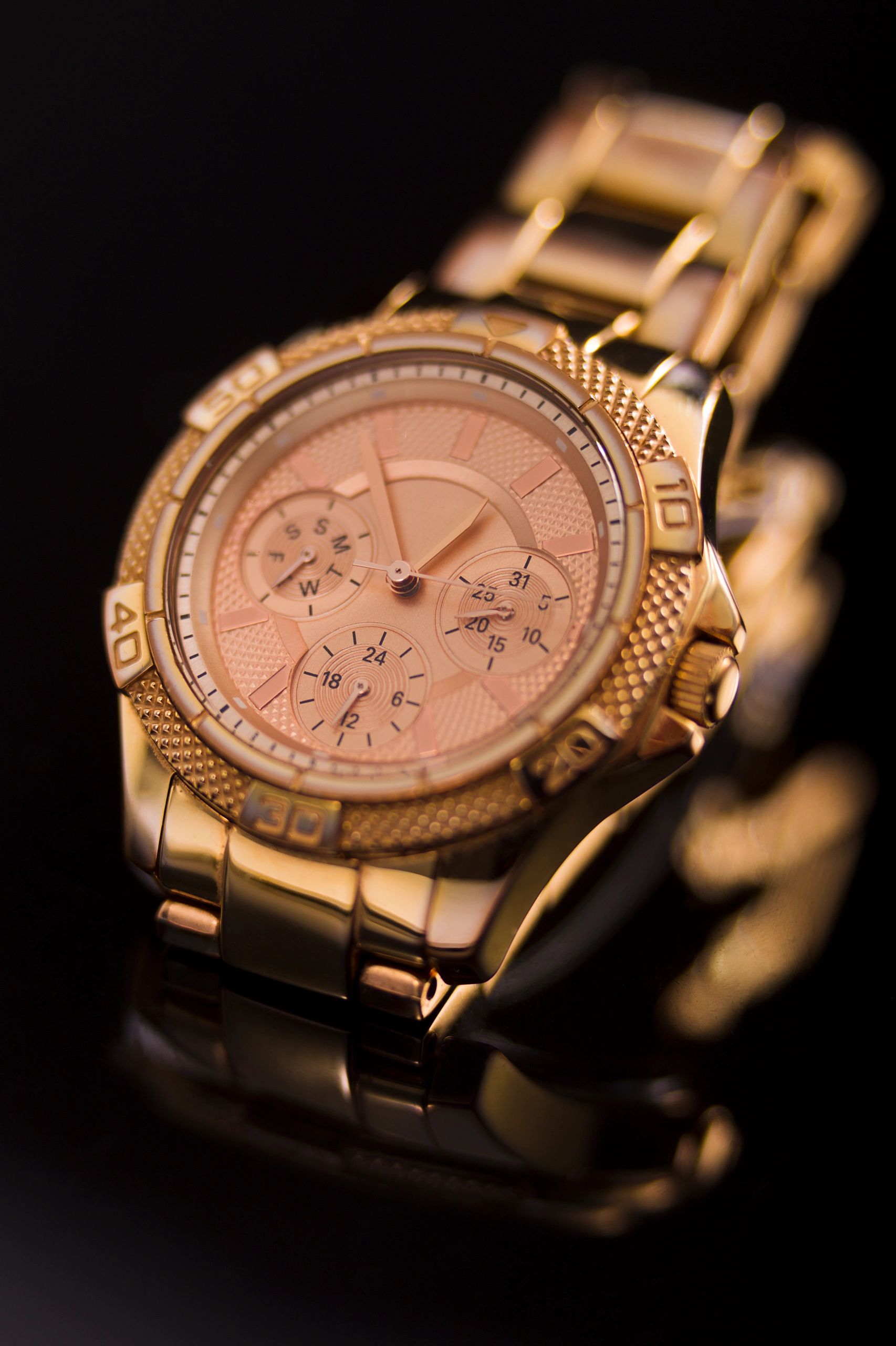 Gold unisex wristwatch in a studio setting